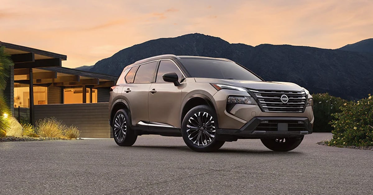 2026 Nissan Rogue parked on a paved driveway in front of a modern home