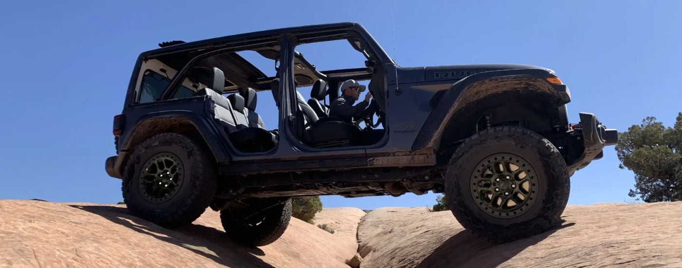 Black 2024 Jeep Wrangler parked on top of boulders