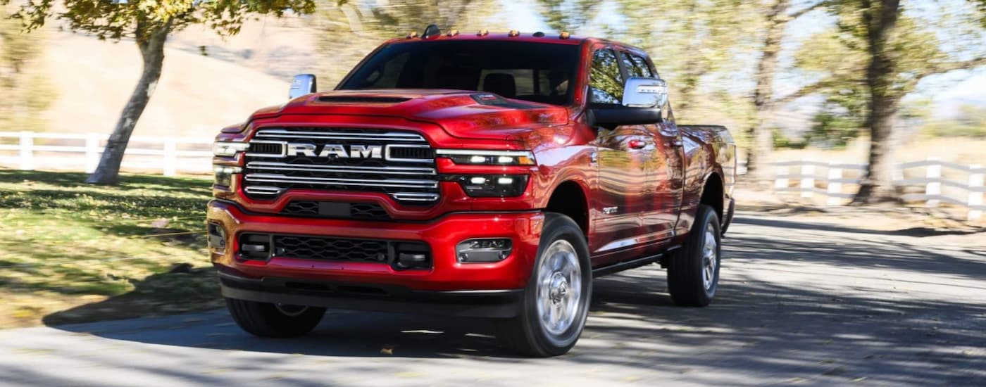 Red 2026 Ram 1500 driving down a road.