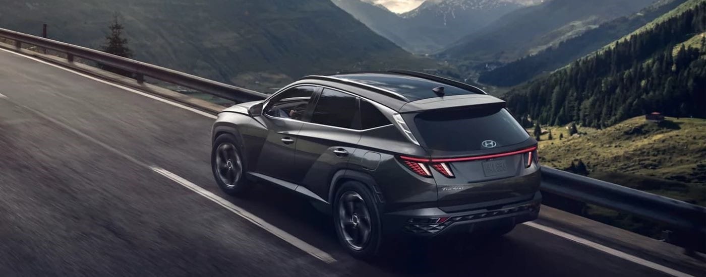 Black 2023 Hyundai Tucson driving down a open road