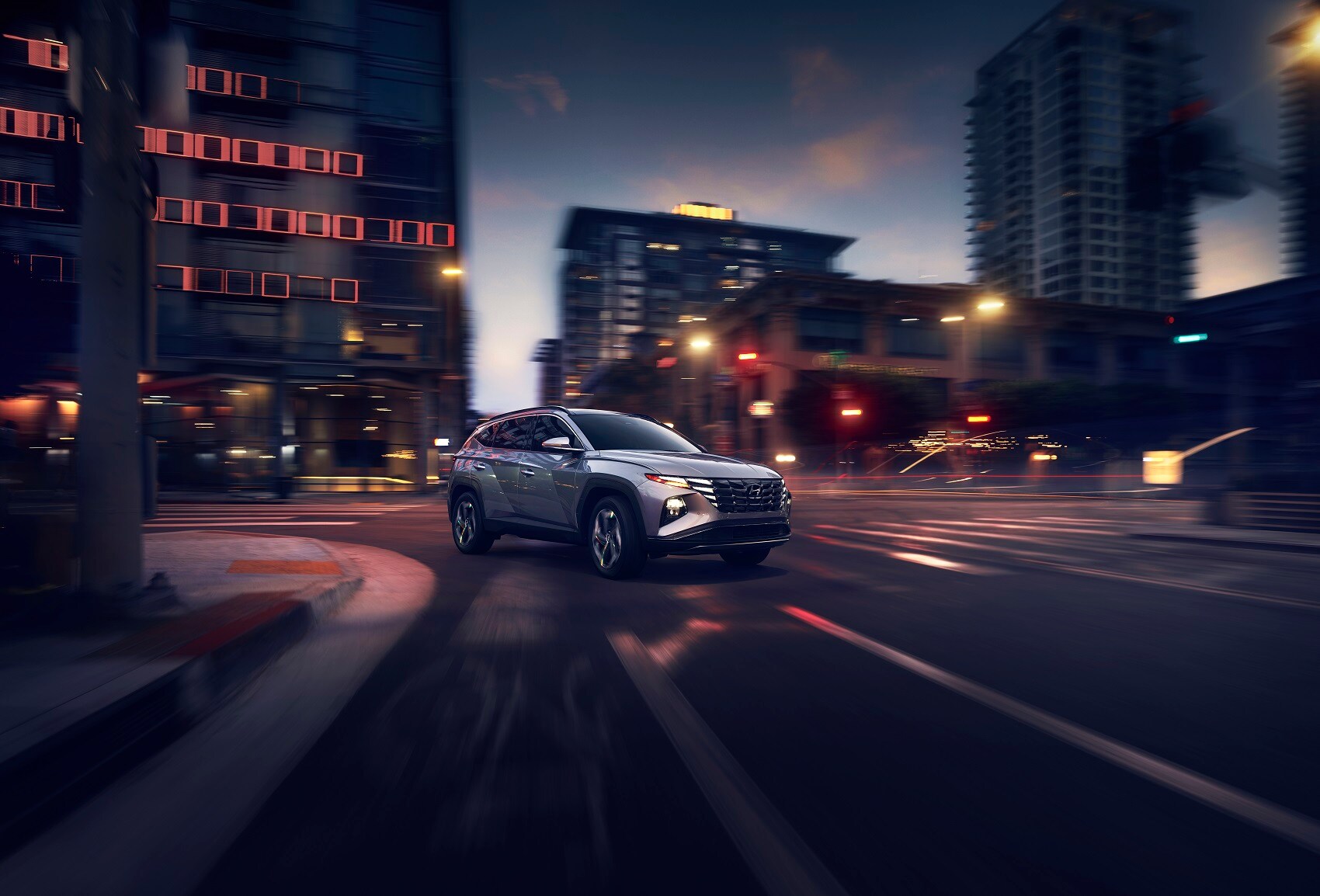 Hyundai Tuscon driving through the city at night - Used Car Dealer near Plymouth CT