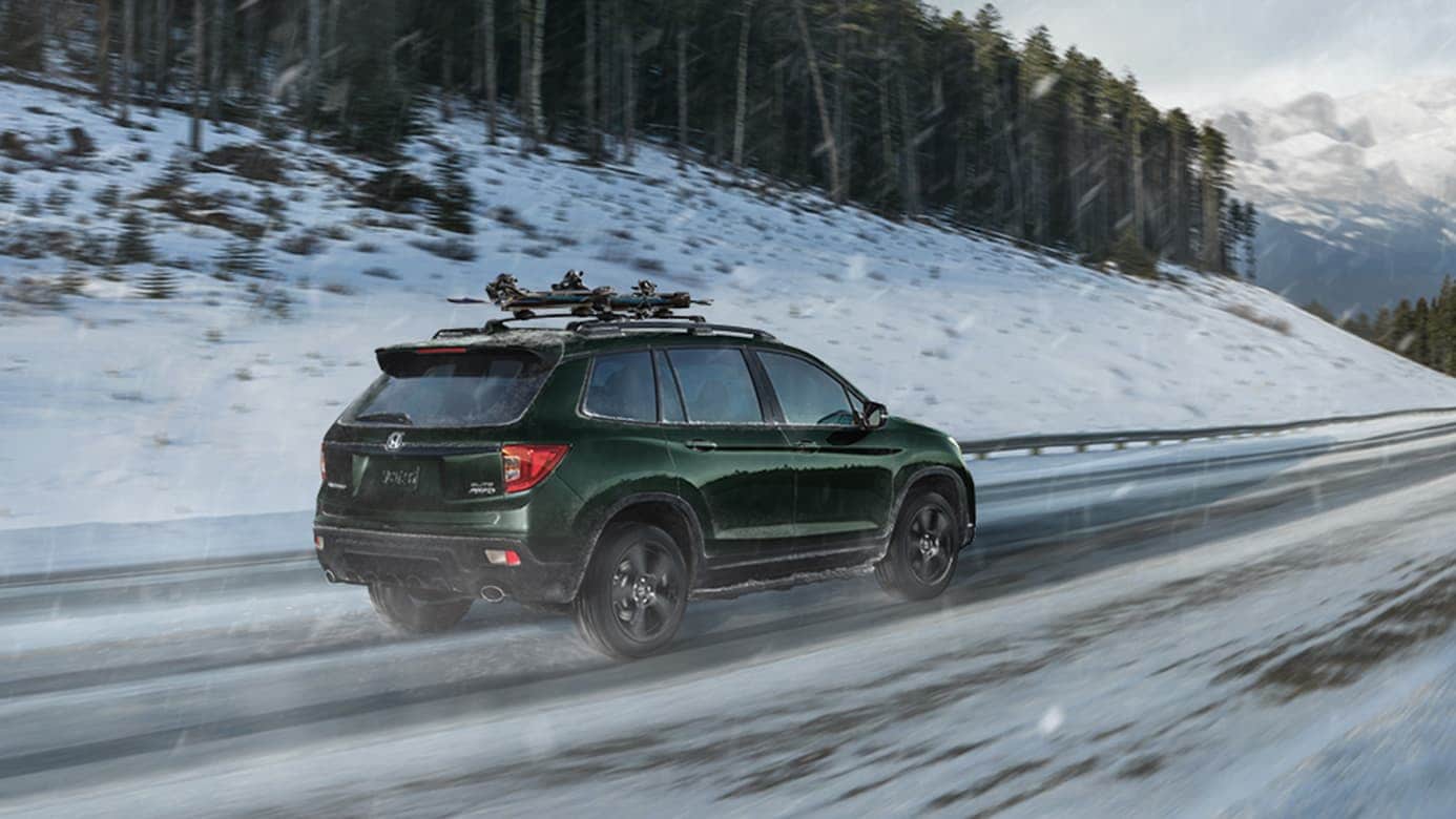 2019 Honda Passport in green driving on snowy road