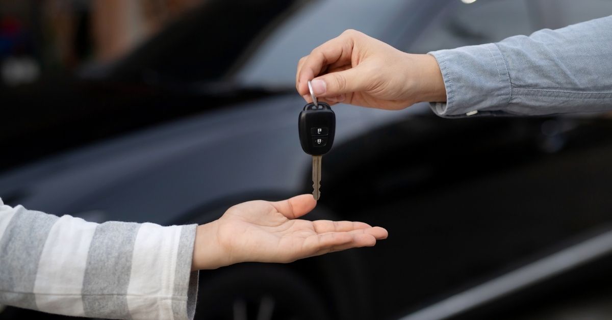 Person handing over keys at a dealership