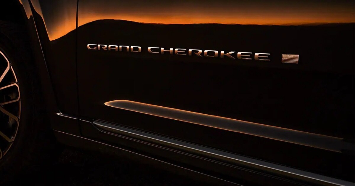 A dramatic close-up of the side of a Jeep Grand Cherokee, showcasing the metallic 