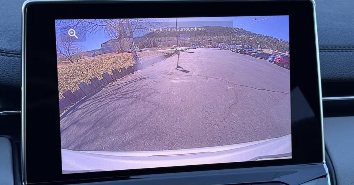 A digital in-car display screen from the 2026 Jeep Compass showing a wide-angle camera view of a parking lot. The screen features the text 