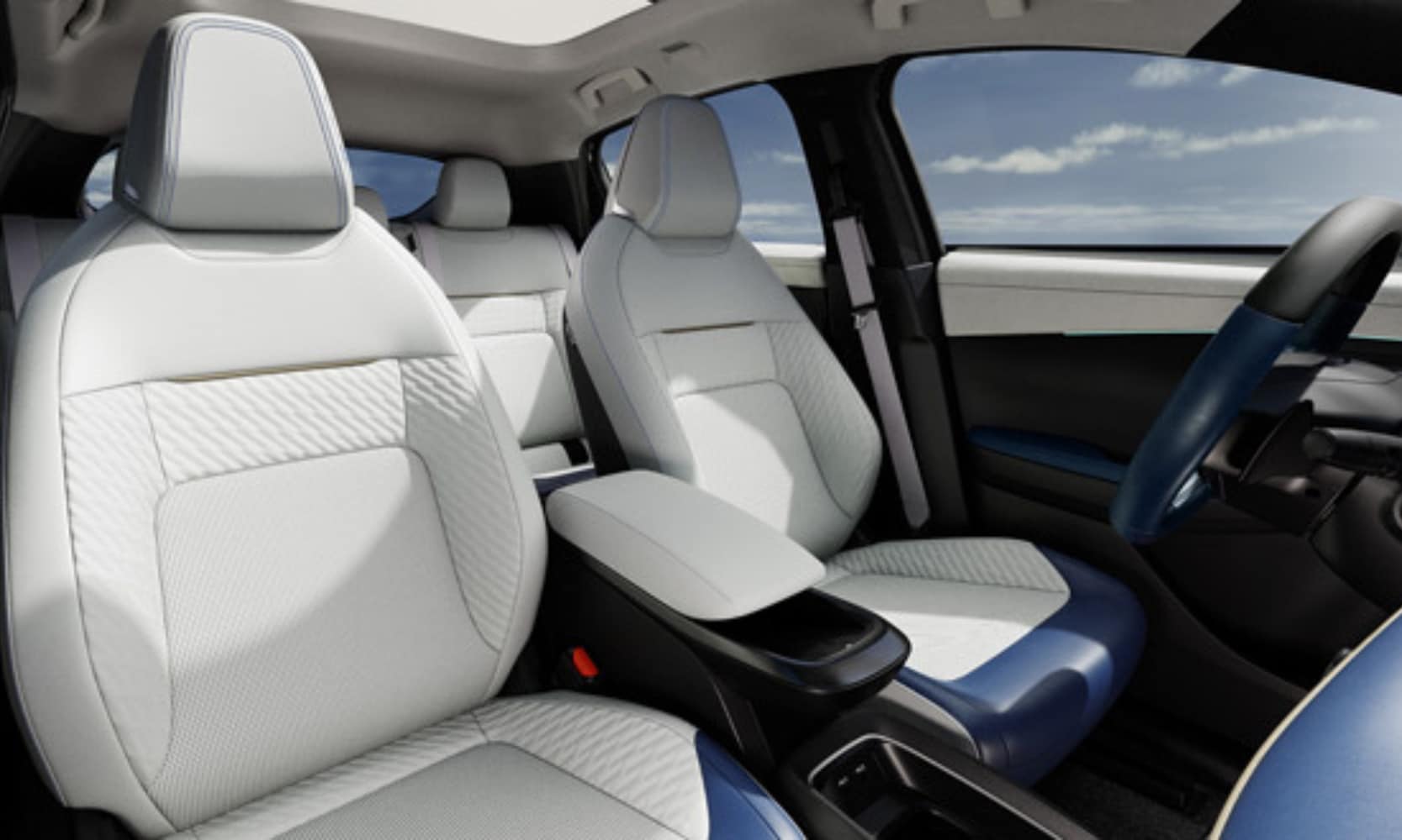 Interior image of the 2026 Nissan LEAF blue and white leather front seats, steering wheel, and a cloudy sky in the background