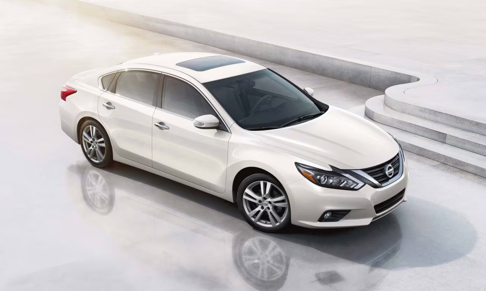 Top-view front angled image of a white 2018 Nissan Altima SL parked in an all-white tile environment
