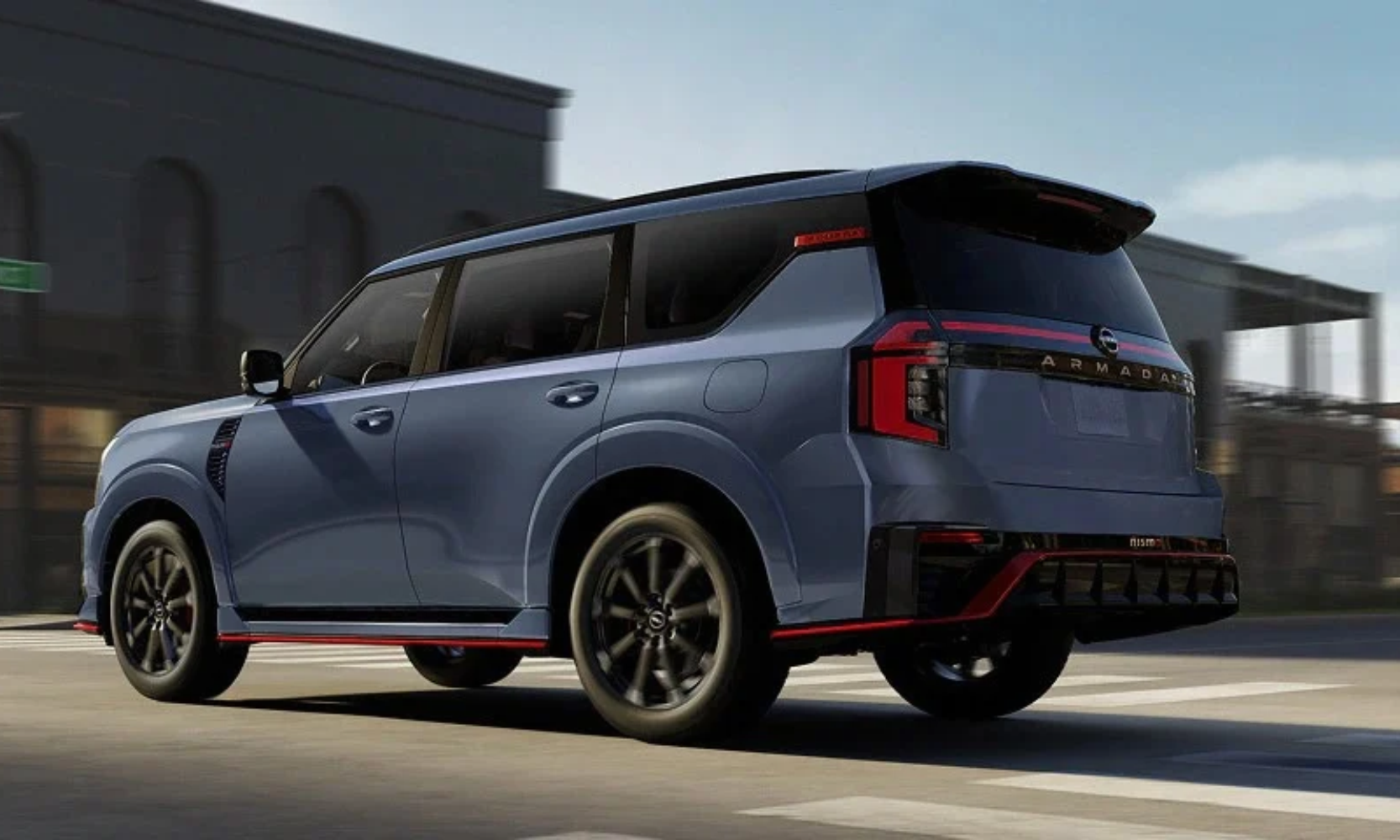 Exterior rear-view image of a blue and red-trimmed 2027 Nissan Armada NISMO driving on a city street