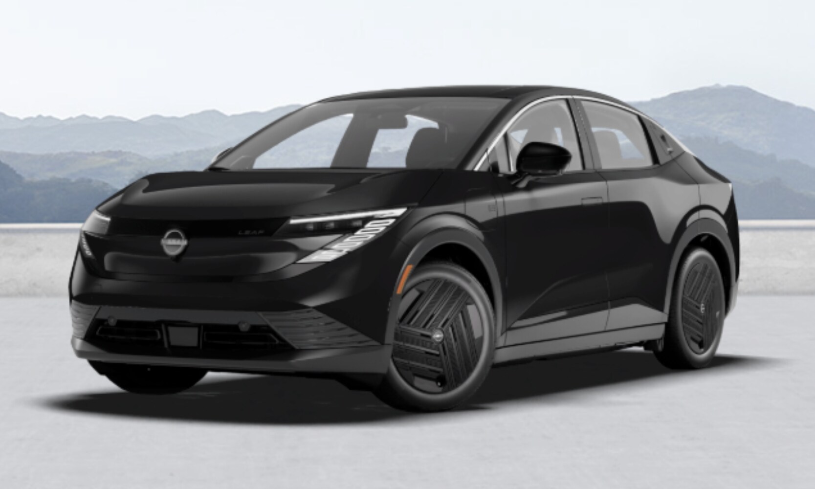 Exterior front side angle image of a black 2026 Nissan LEAF S parked with mountains in the background