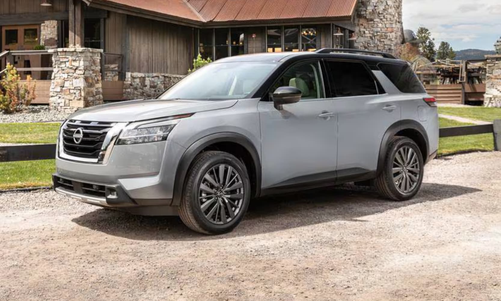 Exterior side image of a light gray 2023 Nissan Pathfinder SL parked in a home's driveway