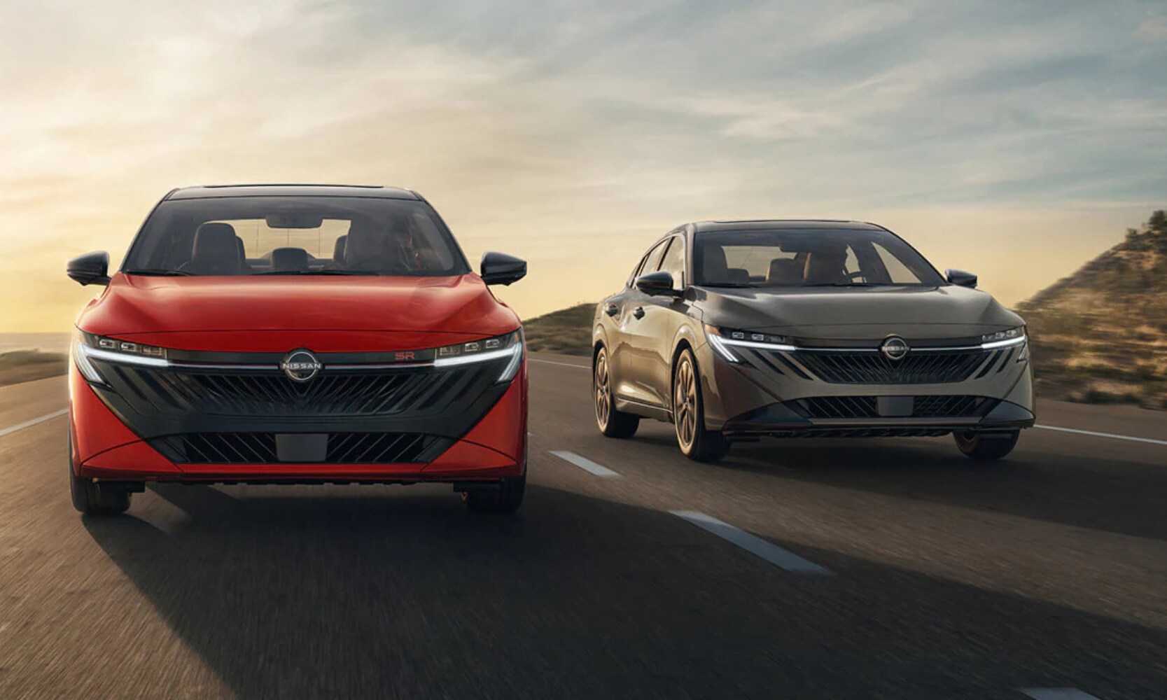 Exterior front image of a red and gray 2026 Nissan Sentra driving side-by-side on an open freeway