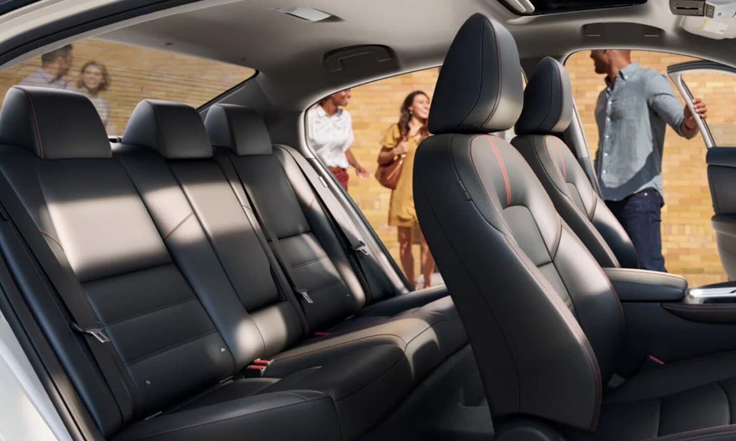 Interior image of a 2025 Nissan Sentra two seating rows with the doors opened and people standing outside