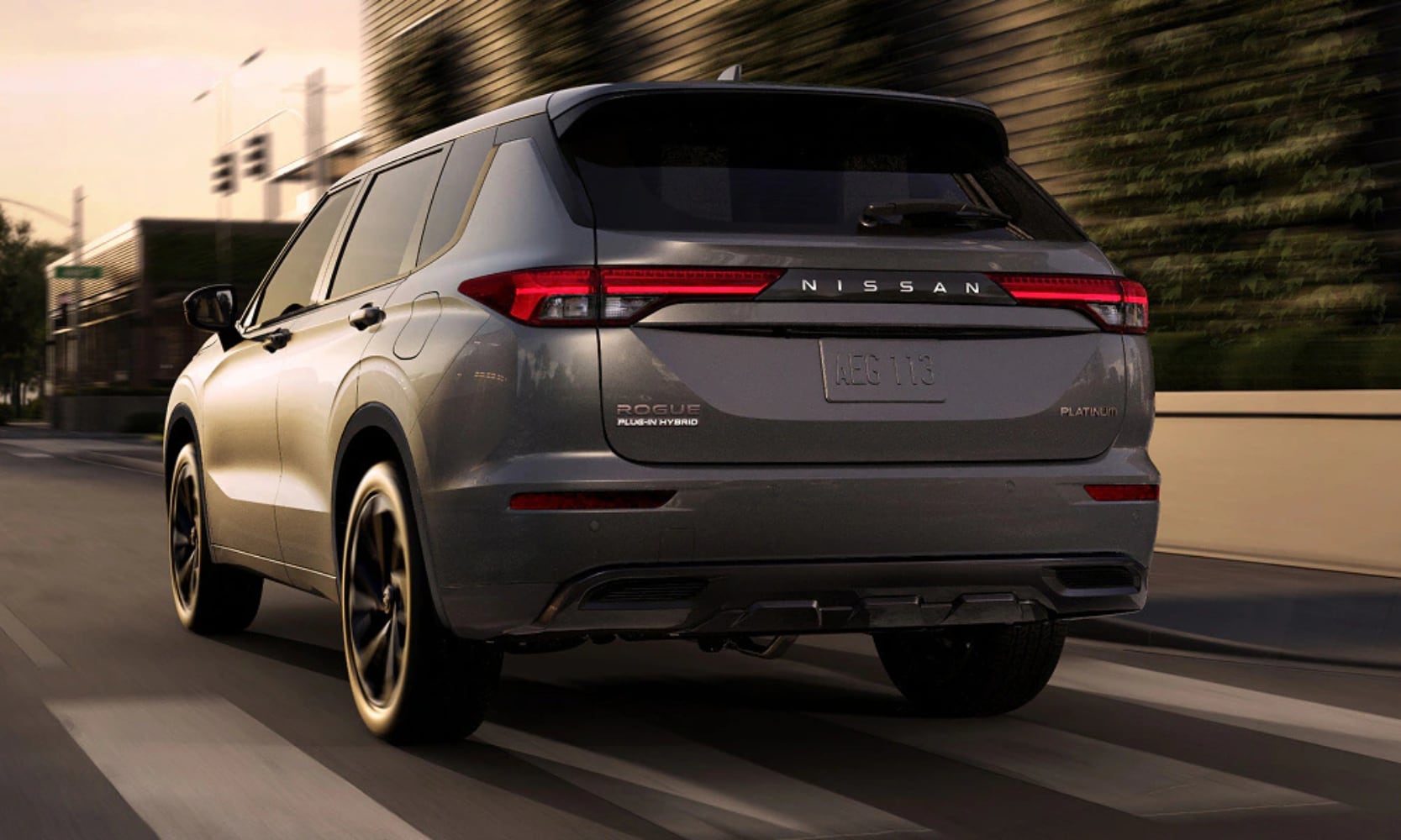 Exterior rear-view image of a gray 2026 Nissan Rogue Plug-In Hybrid Platinum driving on a highway