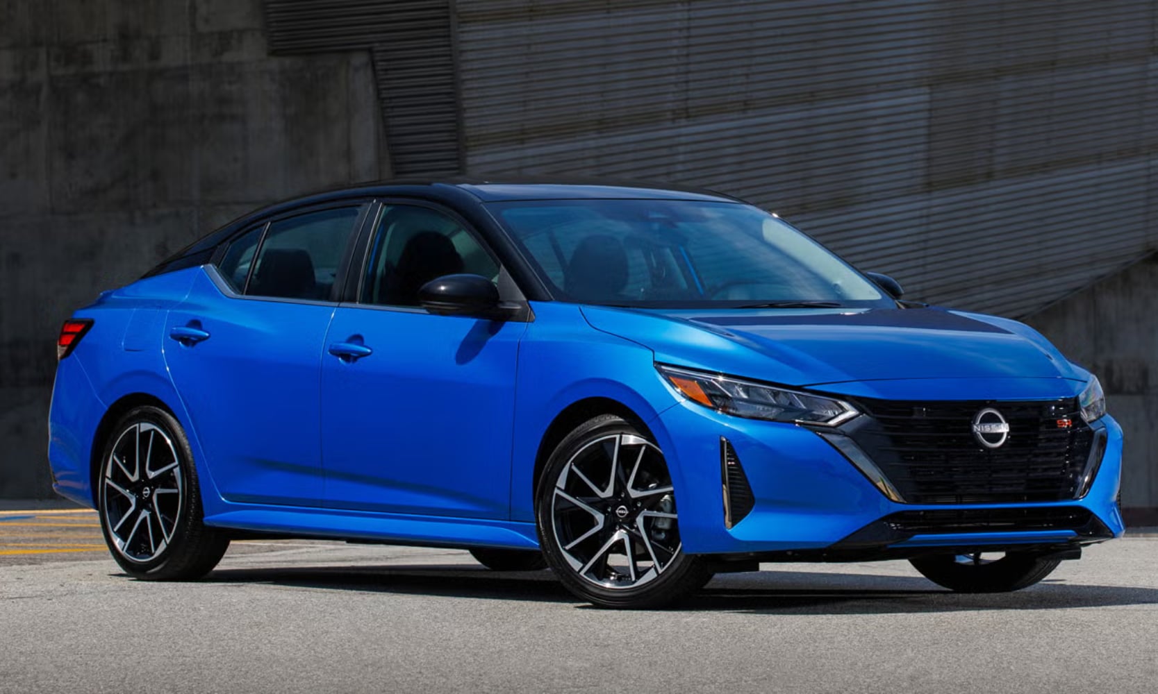 Exterior front side angle image of a blue 2024 Nissan Sentra SR parked on a street