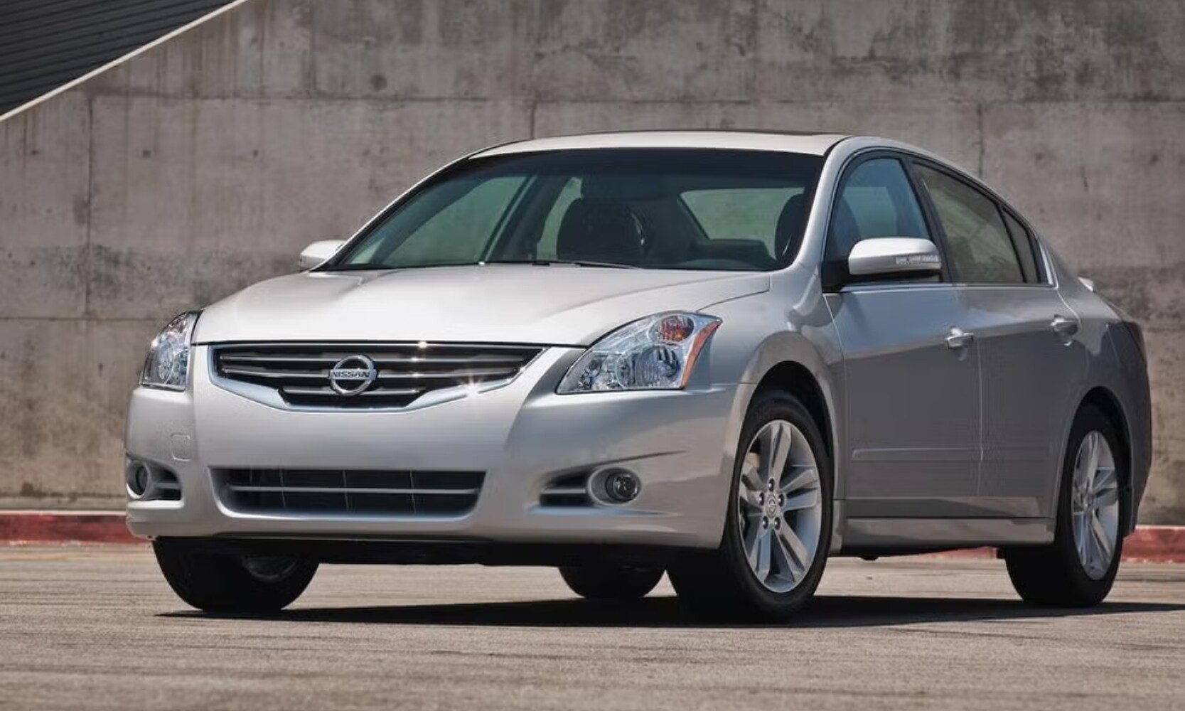Exterior image of a light gray 2010 Nissan Altima parked in a parking lot during the day