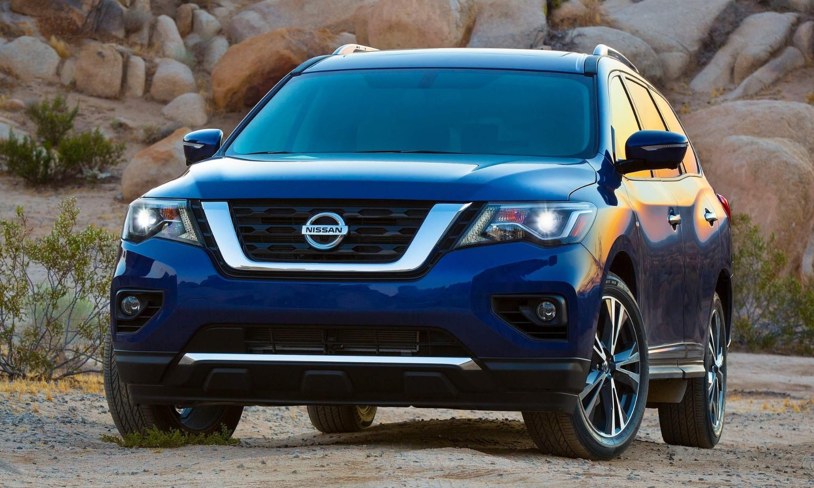 Front-view exterior image of a dark blue 2017 Nissan Pathfinder parked in a rocky landscape