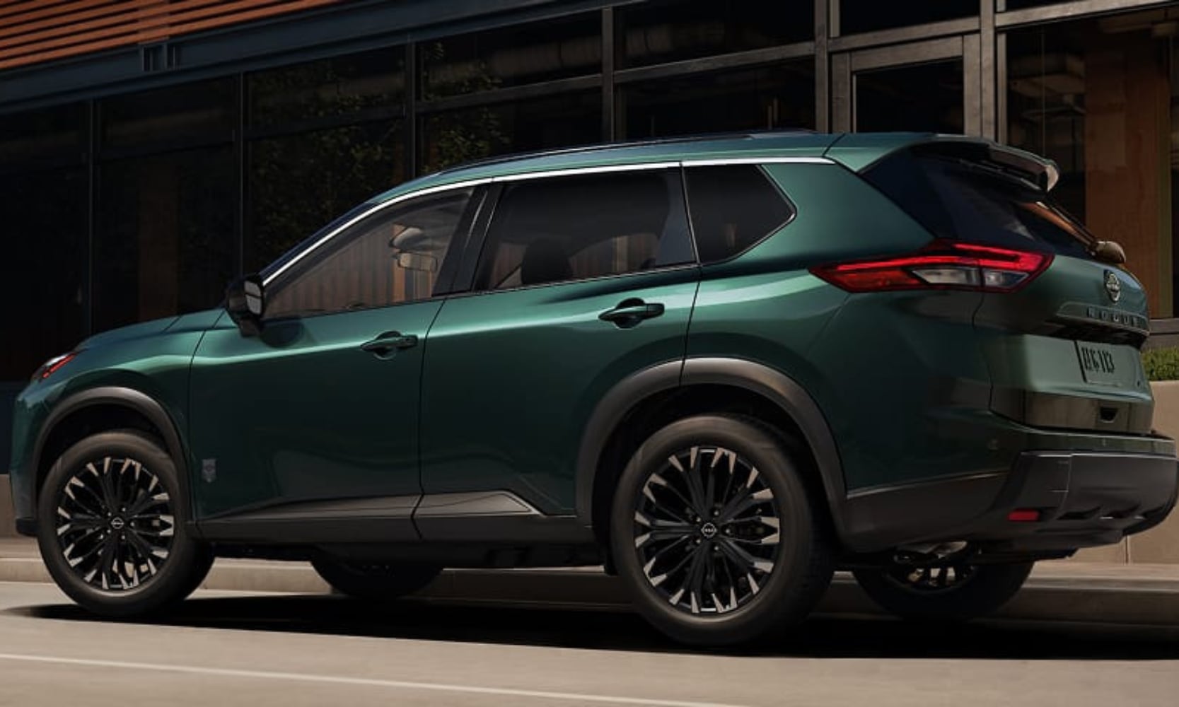 Exterior side image of a 2026 Nissan Rogue Dark Armor parked on a city street