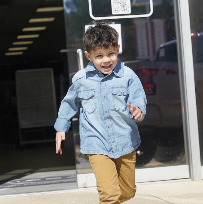 Child running out of dealership smiling
