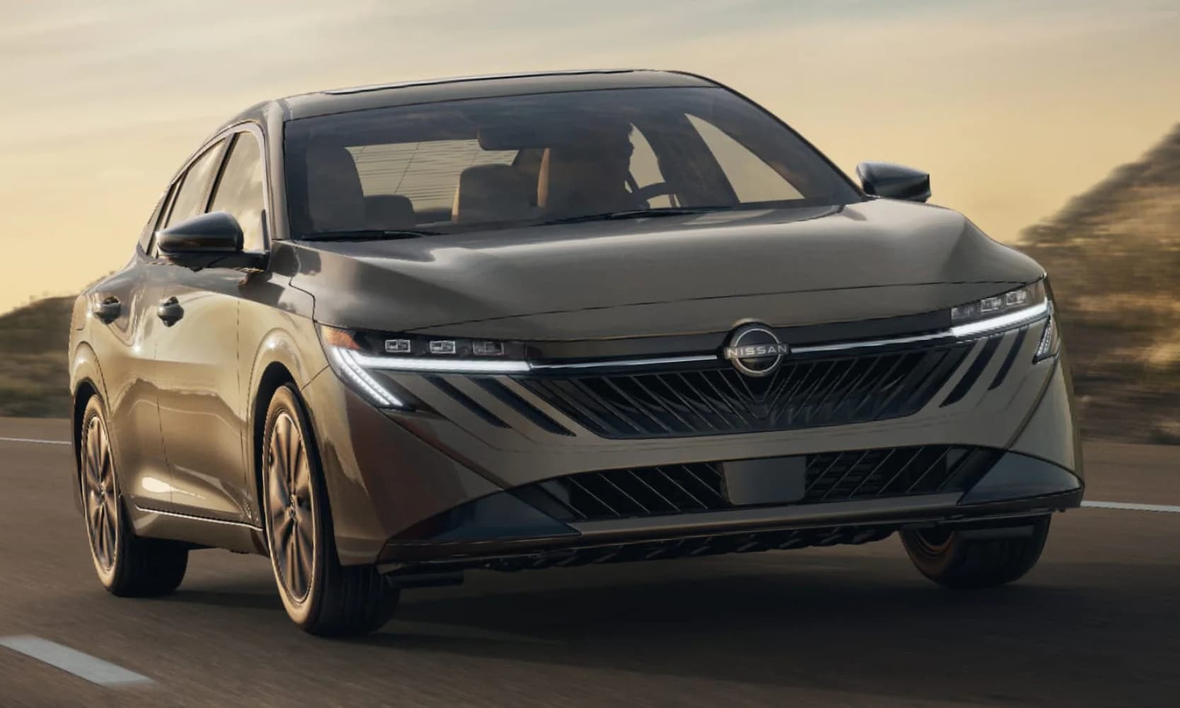 Closeup front exterior image of a gray 2026 Nissan Sentra SL driving on an open road