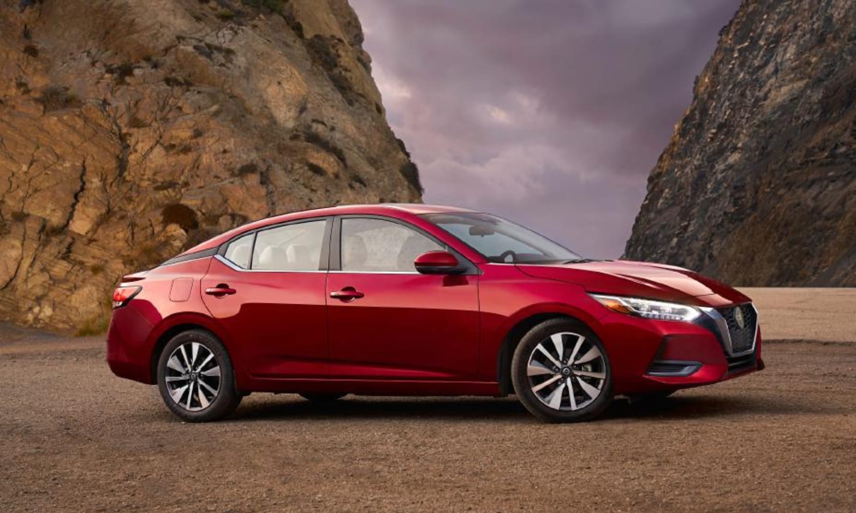 Exterior side image of a red 2021 Nissan Sentra parked on a rocky cliff