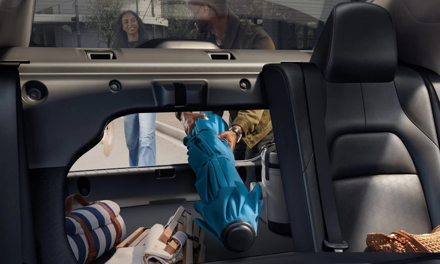 Interior image of people loading beach items in the trunk of a a 2026 Nissan Sentra SR with a rear seat folded down