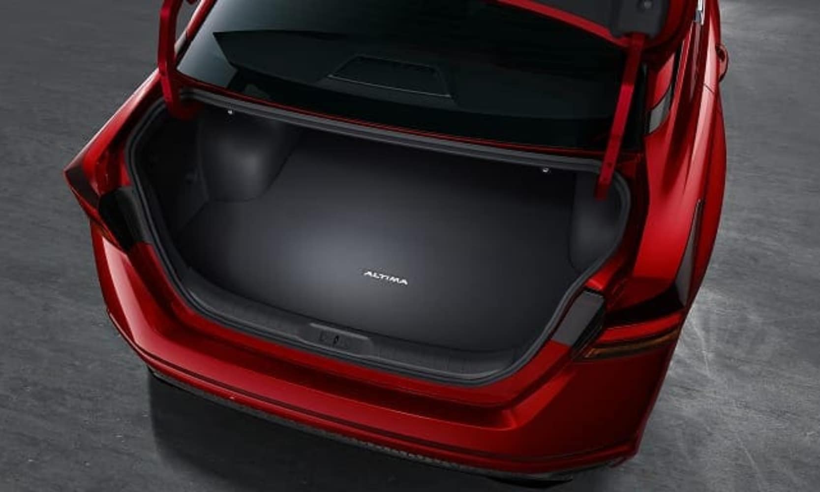Top-view exterior image of a red 2026 Nissan Altima opened empty trunk