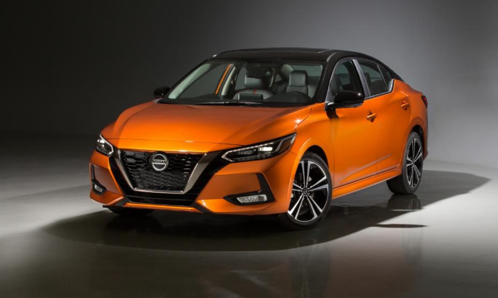 Exterior front image of an orange 2022 Nissan Sentra parked in a showroom