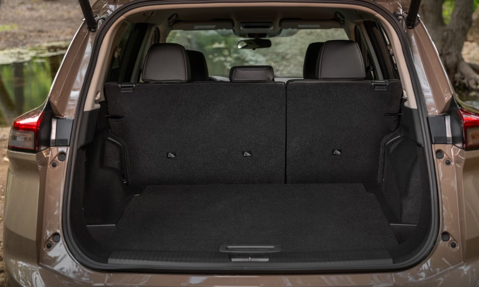 Closeup exterior image of a tan 2025 Nissan Rogue Rock Creek Edition open trunk