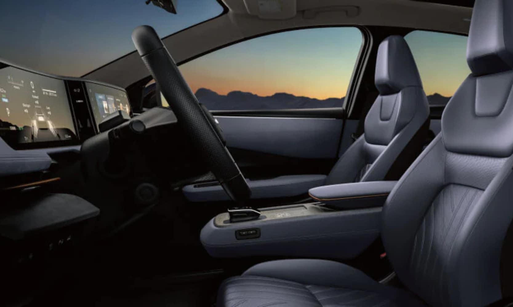 Closeup interior image of a 2025 Nissan ARIYA front seats and dashboard infotainment system with sunset window views