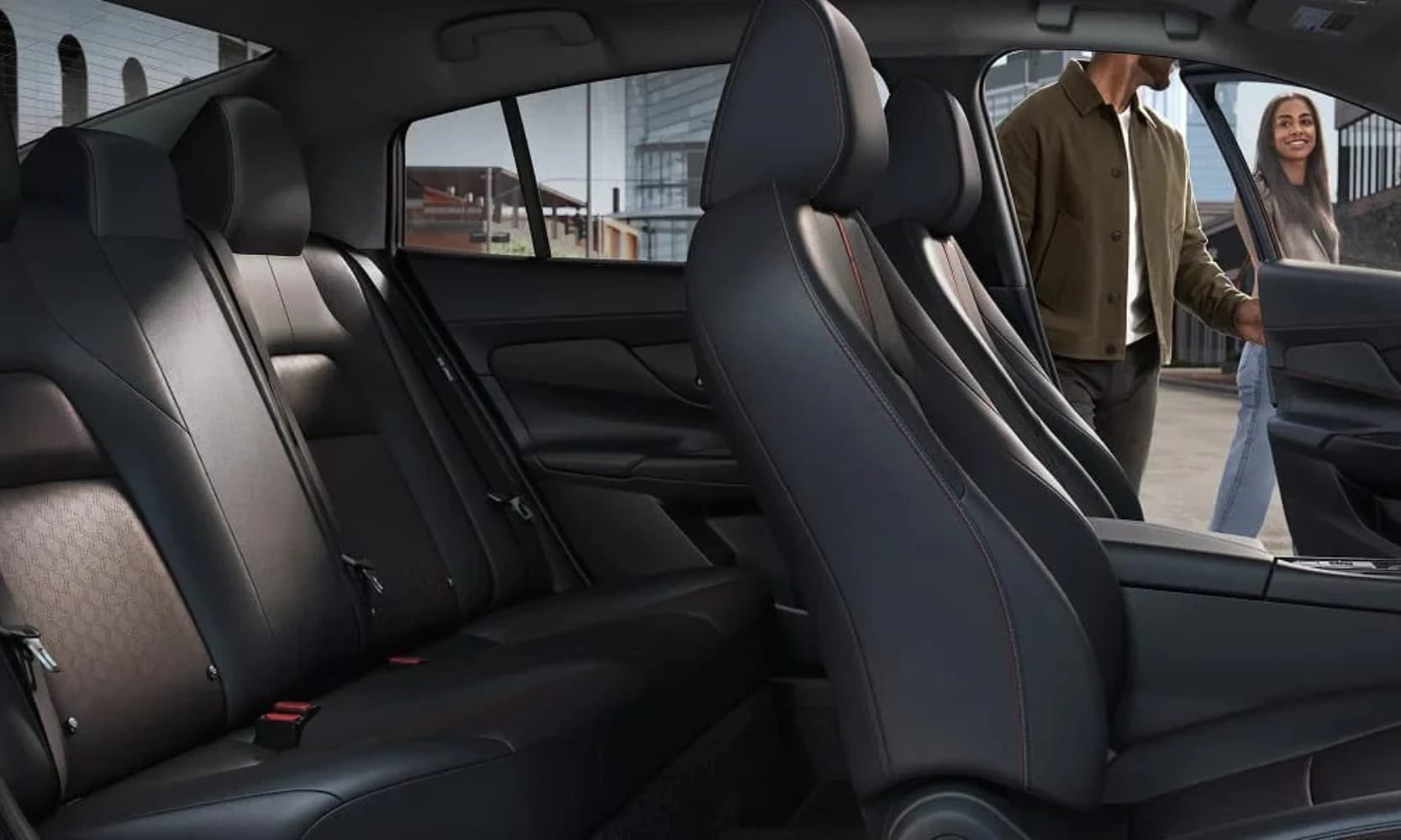 Interior image of a 2027 Nissan Sentra second-row seating with two people in front of an opened driver seat door