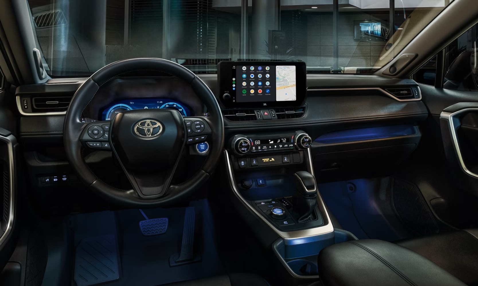 Interior image of the 2025 Toyota RAV4 XSE front seating area and dashboard at night outside a home