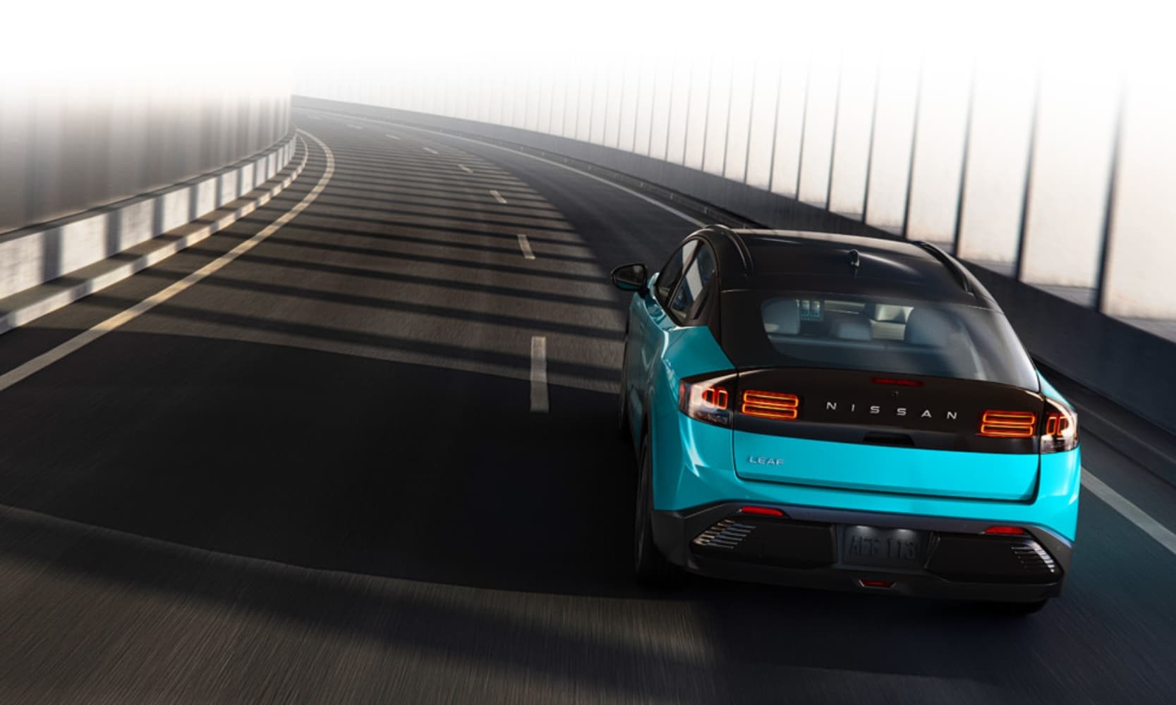 Exterior rear image of an aqua blue 2026 Nissan LEAF Platinum+ driving down an enclosed freeway