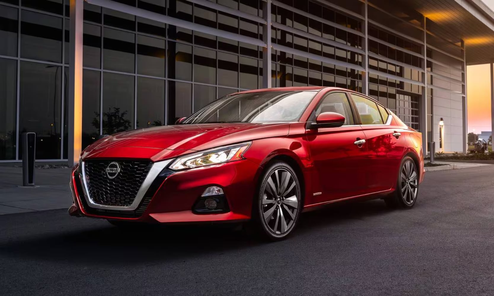 Exterior image of a red 2019 Nissan Altima CV-T Edition ONE parked outside a building during sunset