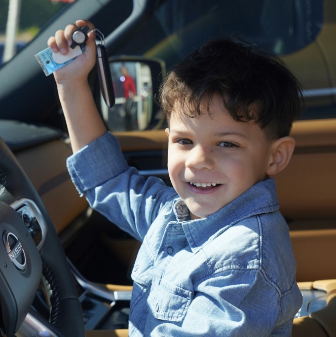 Child holding car keys inside a vehicle