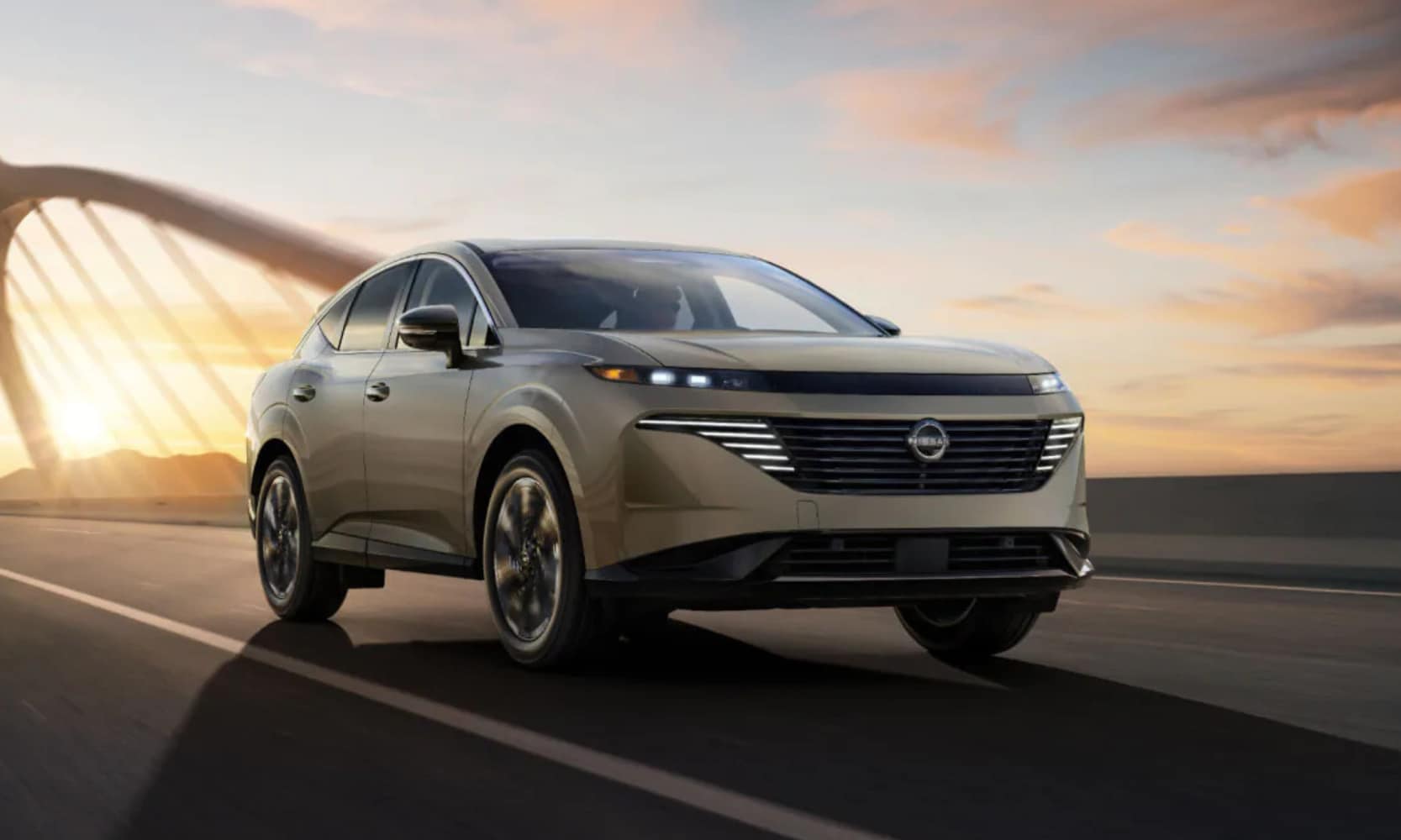 Exterior front image of a taupe 2025 Nissan Murano driving over a bridge during sunset