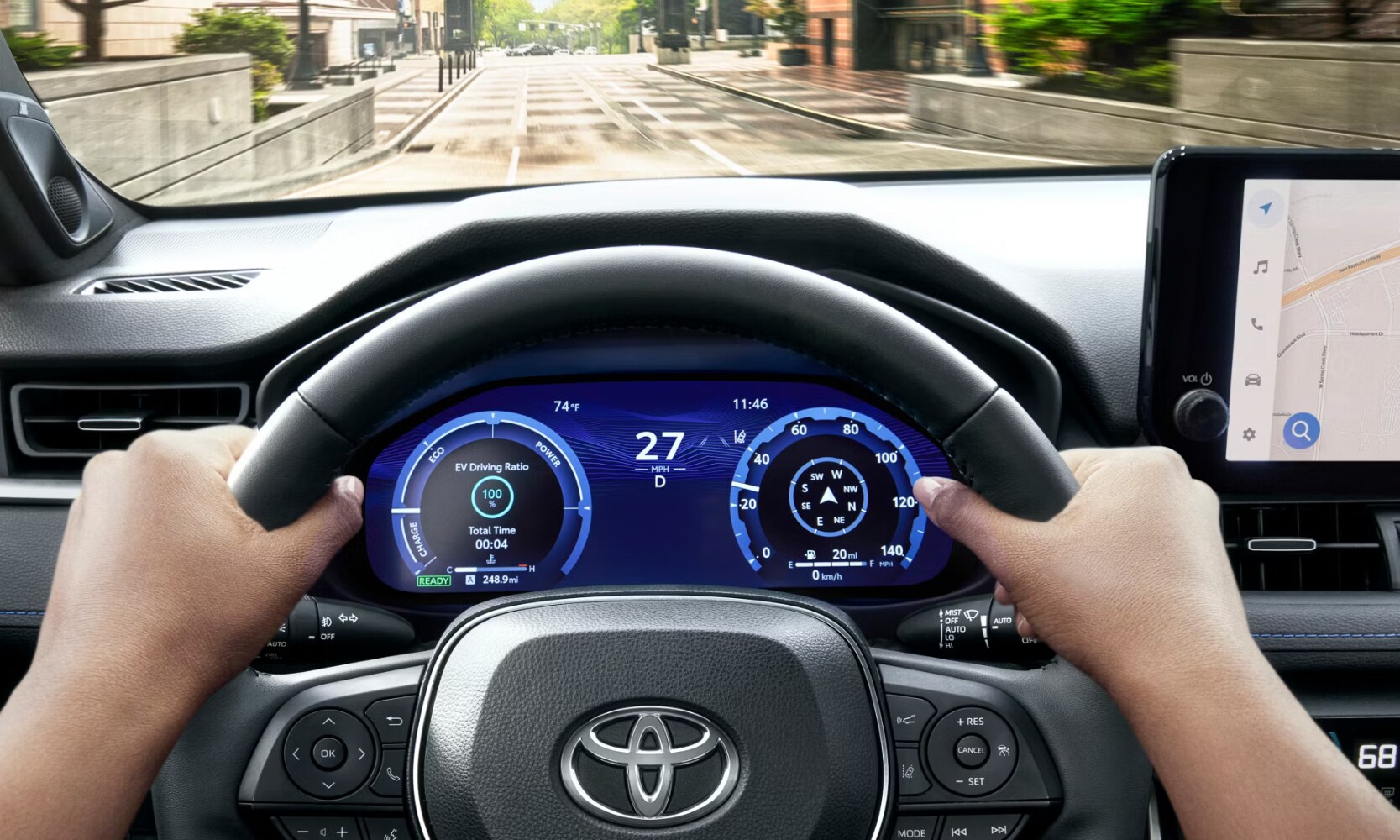 Closeup interior image of a driver's hands holding the 2025 Toyota RAV4 steering wheel driving on a city street