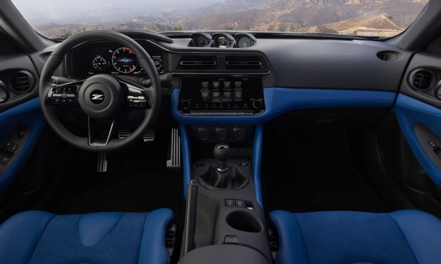 Interior image of the 2025 Nissan Z blue leather seats and dashboard with mountain windshield views