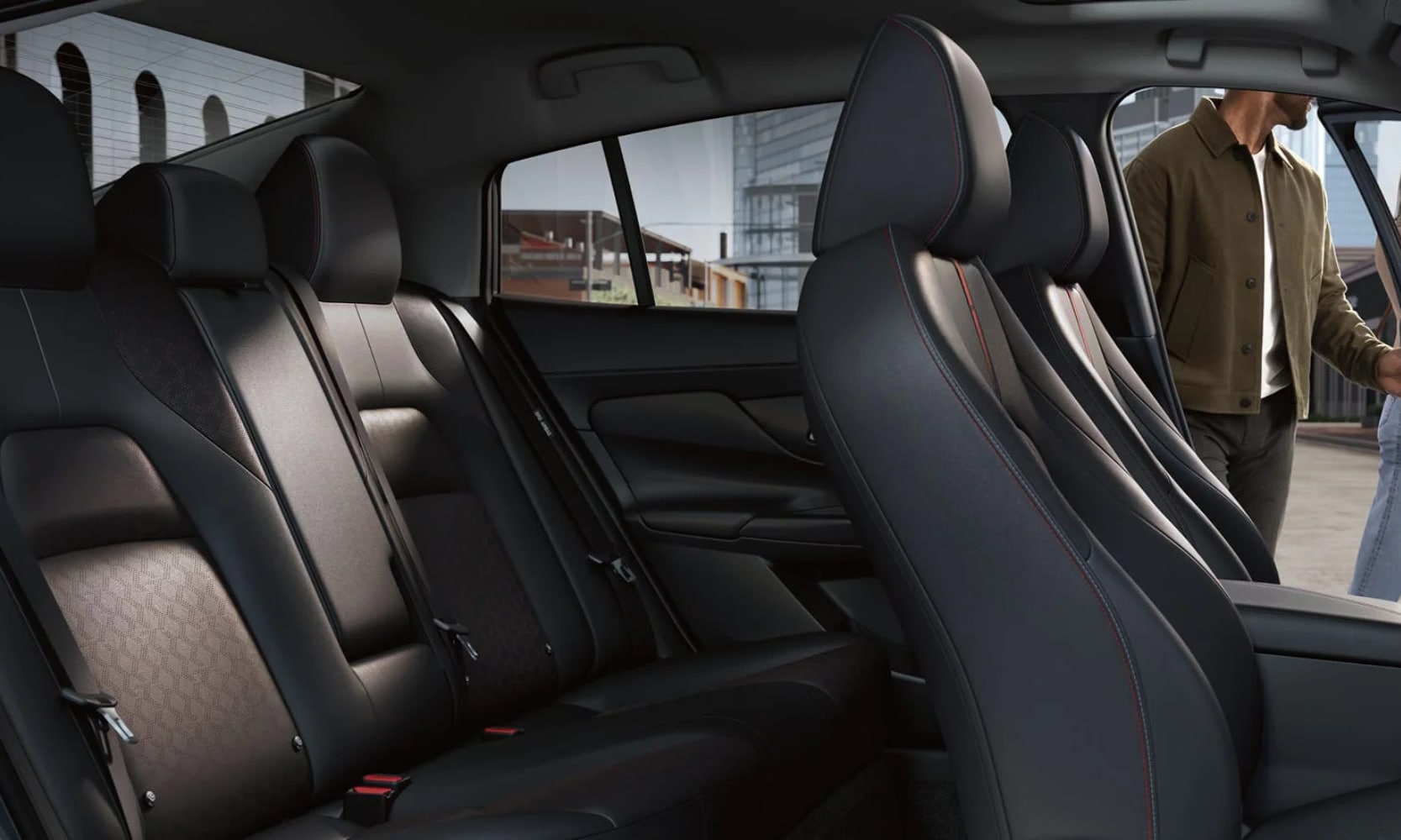 Closeup interior image of the 2026 Nissan Sentra SR black leather two seating rows with a person opening the driver's door