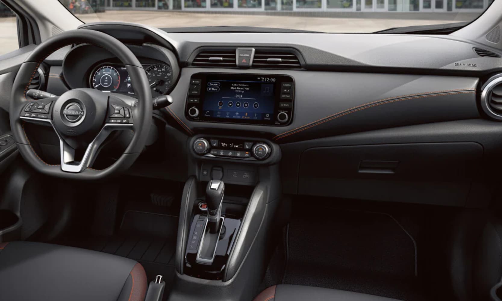 Interior image of a 2025 Nissan Versa's gray front seat area, dashboard, and infotainment system