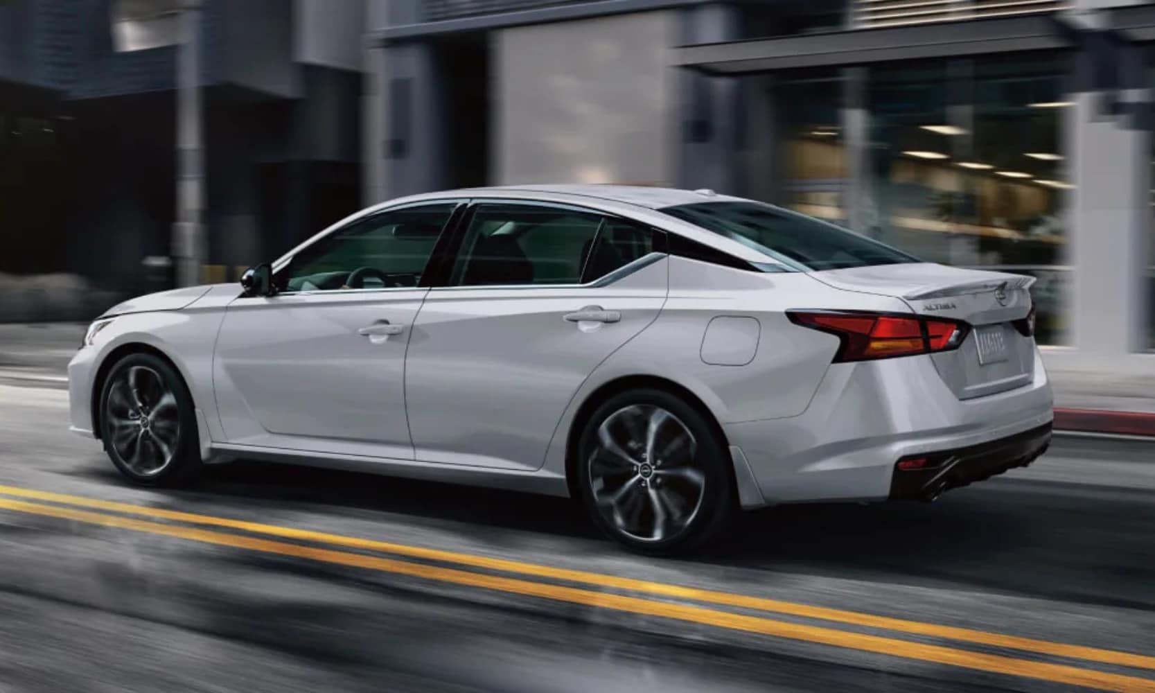 Exterior side image of a white 2025 Nissan Altima driving down a city street