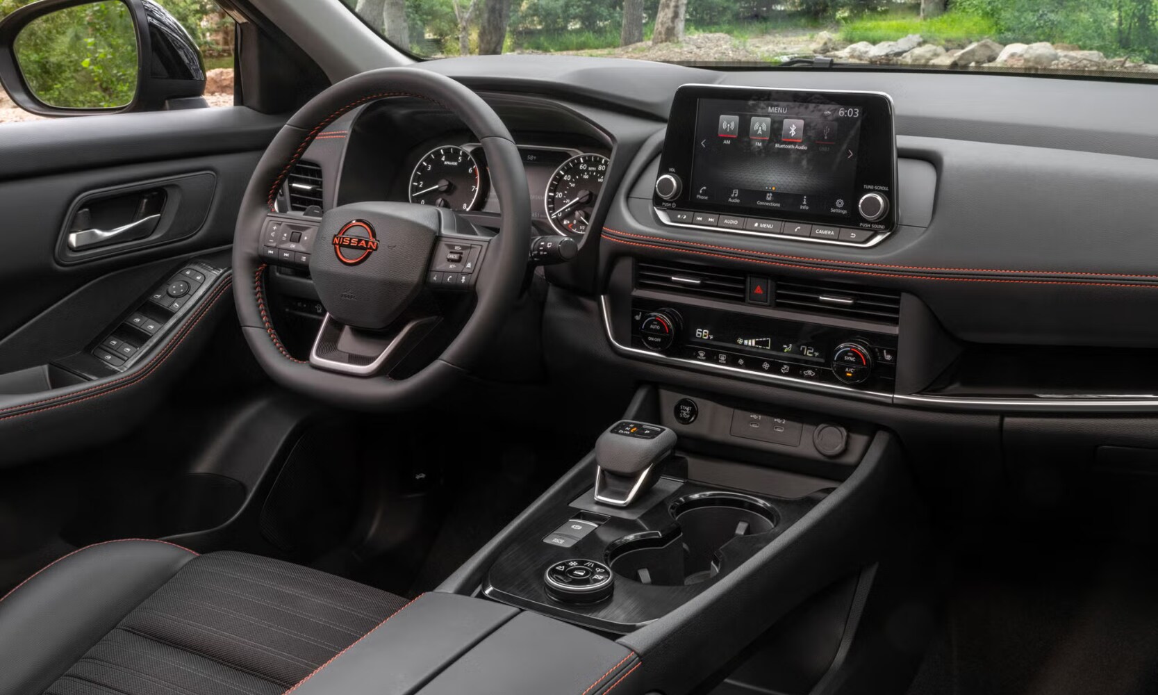 Interior image of a 2025 Nissan Rogue Rock Creek Edition front seat area and infotainment system