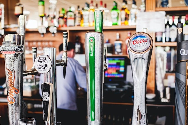 four silver beer tap handles at a sports bar