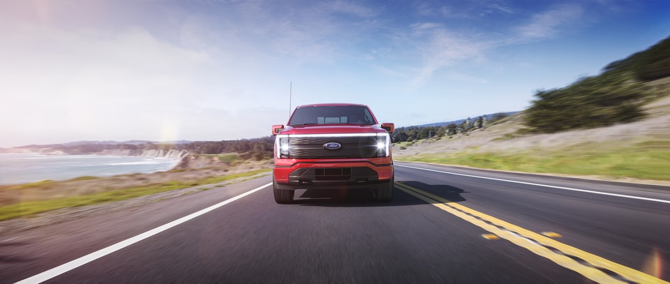 red Ford F-150 Lightning driving on highway near Sioux Falls, SD