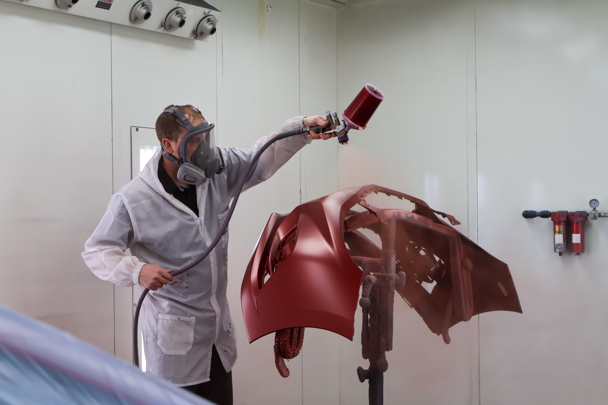 Sleepy Hollow Collision Center technician painting a fender