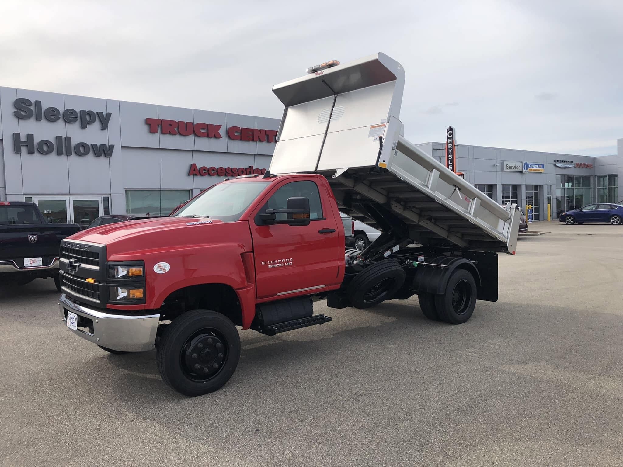 Aluminum Rugby dump body on a red work truck for hauling landscape material