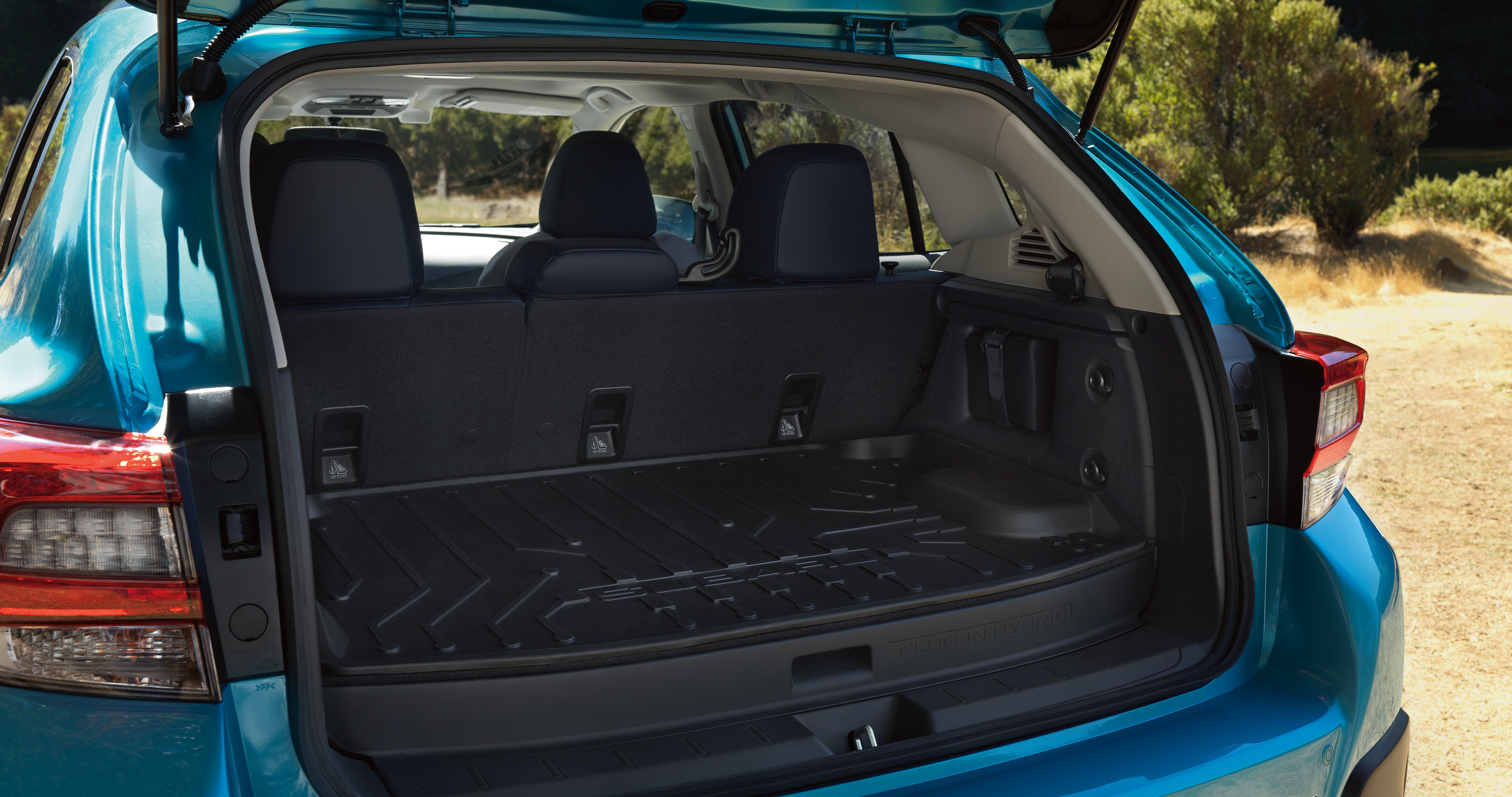  An exterior view of the rear cargo area of the 2023 Crosstrek Hybrid with the rear seatbacks folded down.