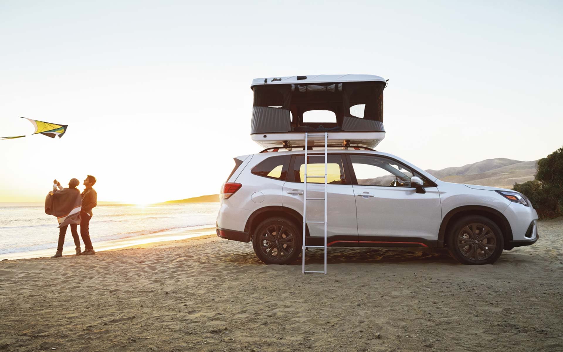 The 2022 Forester Sport parked on a beach with roof tent.