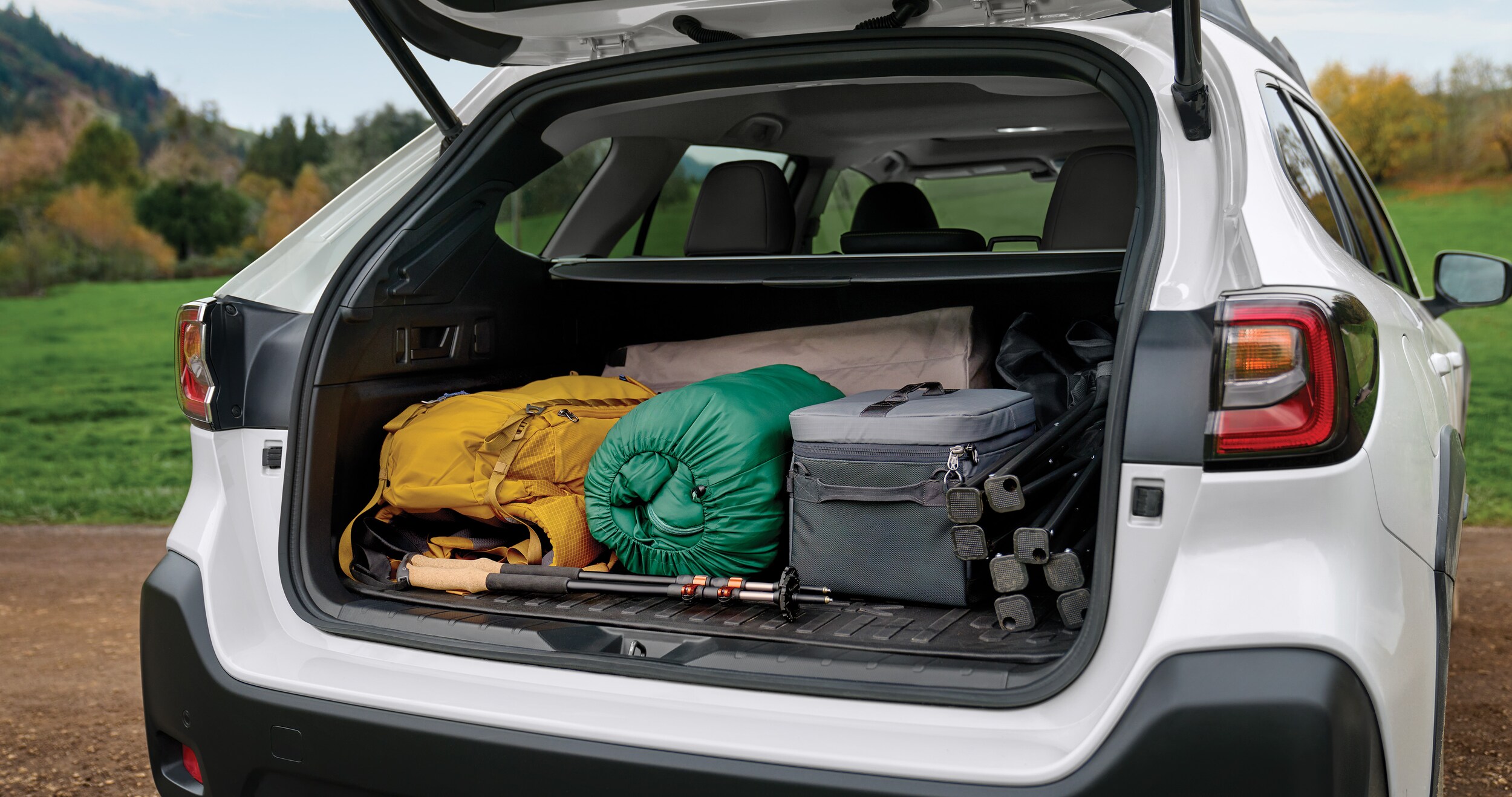 A view of the open rear cargo area of the 2023 Outback loaded with gear.