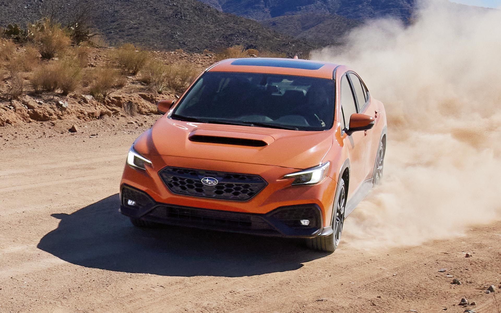The 2022 Subaru kicking up dirt while driving on a desert road.  