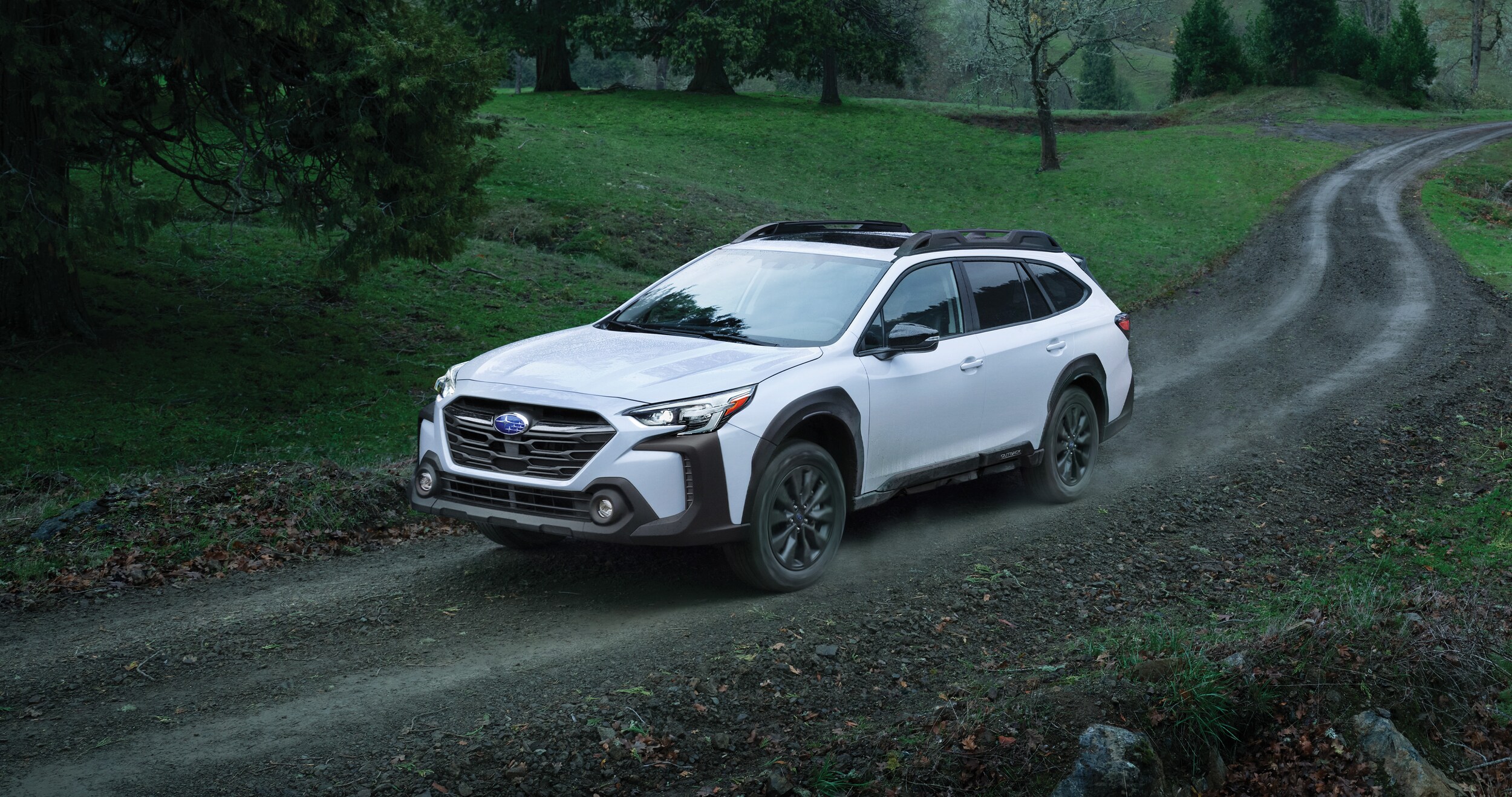 A 2023 Outback driving on a dirt road.